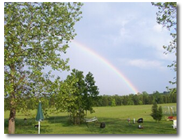 a photo of a farm scene with a rainbow